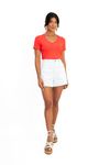 Modelo vestindo um short branco com uma camiseta vermelha, vista frontal.