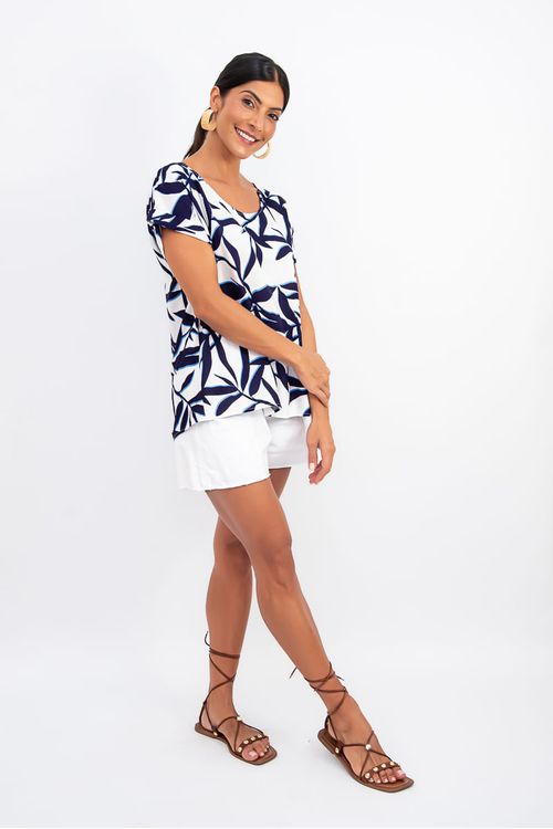 Blusa botânica com estampa de folhagem, decote canoa e mangas morcego dobradas, vista lateral.