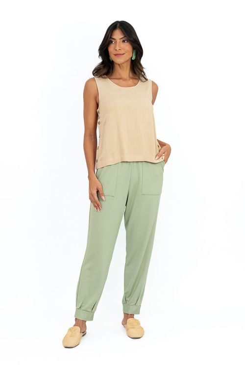 Blusa bege sem mangas com decote em U e botões laterais, combinada com calça verde clara, vista completa.