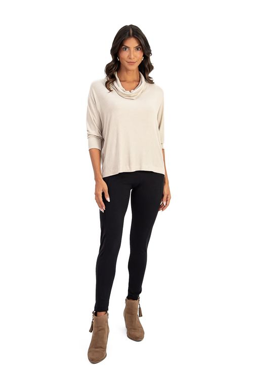 Modelo vestindo calça legging montaria preta com blusa bege e botas marrons, em pose lateral.