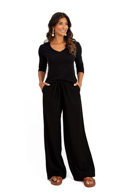 Calça reta preta com amarração e blusa preta de manga longa, vista frontal.