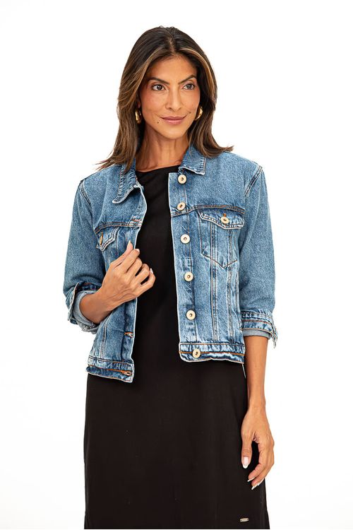 Jaqueta jeans azul médio com bolsos e detalhes em costura zig-zag, vista frontal.