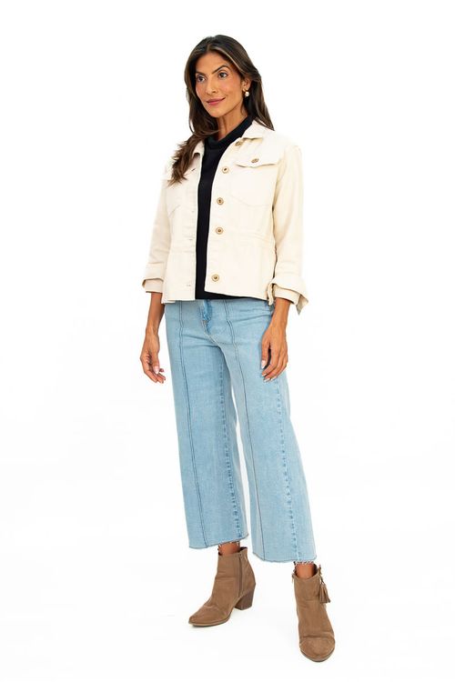 Modelo vestindo jaqueta básica em sarja Delfi na cor baunilha, combinada com calça jeans.