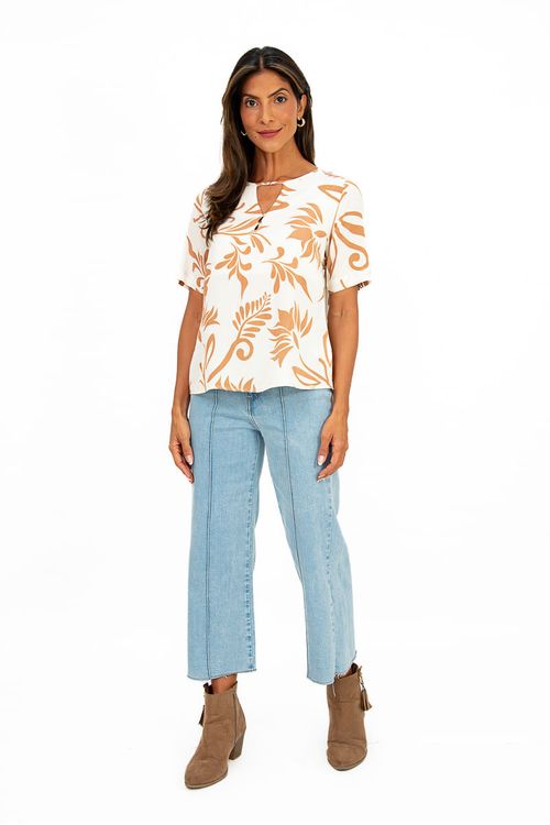 Modelo vestindo blusa estampada com calça jeans e botas, vista completa.