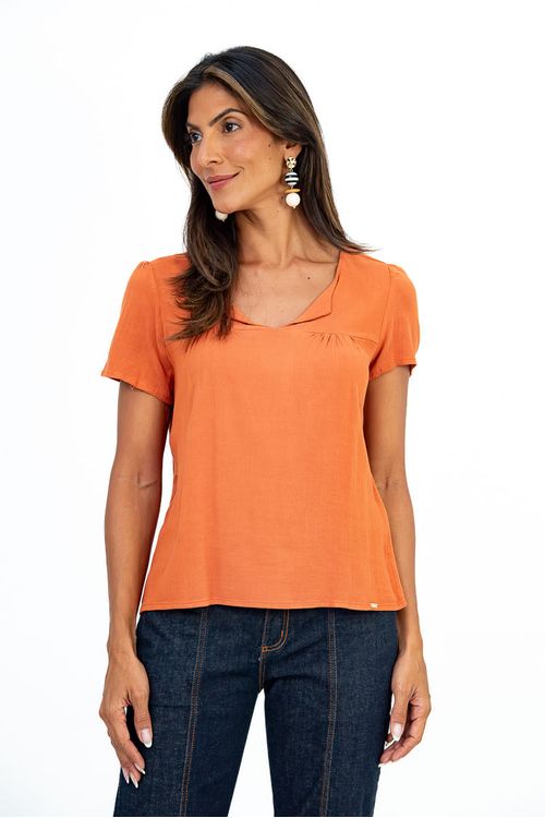 Blusa feminina em tecido plano de cor telha, com decote em V e frente franzida, vista frontal.