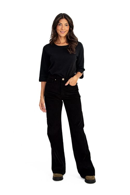 Modelo vestindo calça wide leg de veludo canelado preto, com blusa preta de manga longa.