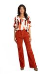 Modelo vestindo calça wide leg de veludo canelado caramelo com blusa estampada, vista frontal.