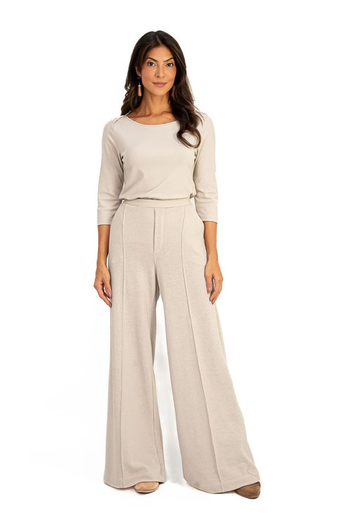 Blusa de malha viscose baunilha com detalhe de transpasse no ombro, combinada com calça.