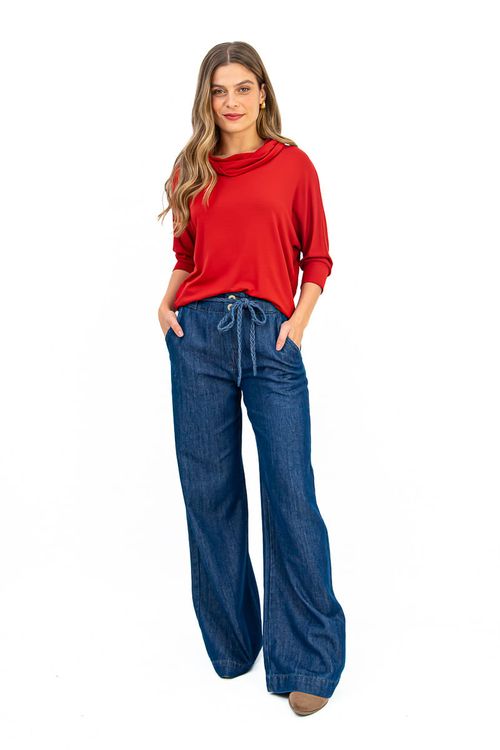 Modelo vestindo blusa morcego terracota com maxi gola e calça jeans.