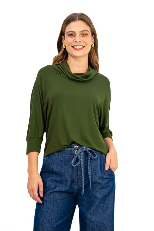 Blusa verde escuro com maxi gola e mangas morcego, combinada com calça jeans.