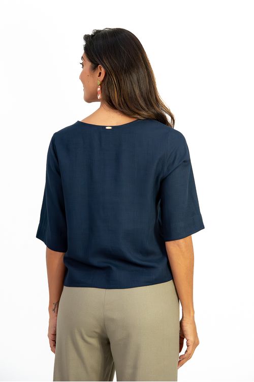 Blusa-em-linho-Amber-com-decote-V-botoes-frontais-e-meia-manga.-Detalhe-de-pala-nas-costas-e-aberturas-laterais-trazem-leveza-e-sofisticacao.