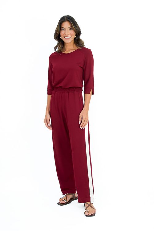 Close lateral da blusa bordô mostrando a fenda na manga e a costura estilo raglan, tecido com caimento fluido
