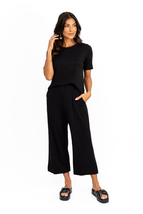 Modelo-vestindo-calca-pantacourt-preta-em-viscose-vista-frontal-com-bolsos-faca-e-cos-elastico-visual-minimalista.