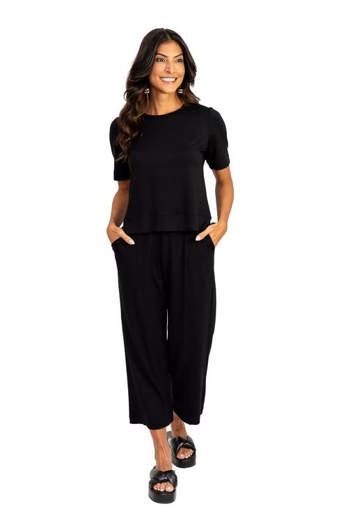 Look completo com blusa preta cropped viscose e calça preta de perna ampla, visual urbano minimalista, modelo caminhando