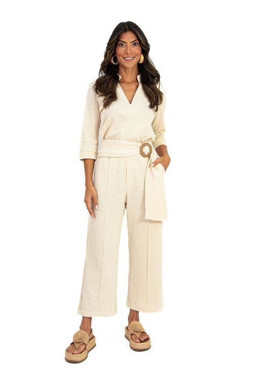 Modelo usando Blusa Gola Larga Baunilha com cinto de fivela redonda e calça de cintura alta, vista meia-corpo.