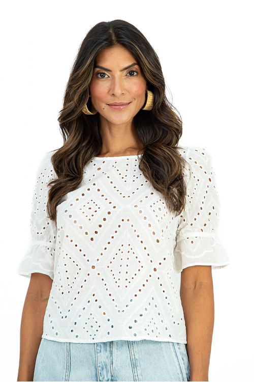 Close frontal da blusa algodão laise branca mostrando os detalhes de broderie em losangos e acabamento perfurado