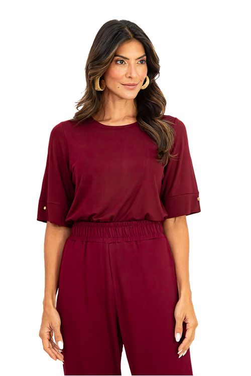 Close-up da blusa Flórida bordô com decote canoa, meia-manga com punho e botão, em malha viscose de caimento fluido