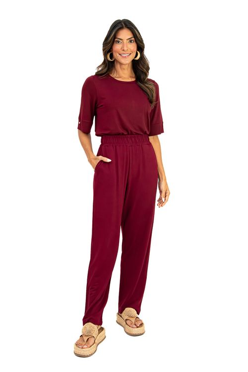 Modelo usando conjunto bordô: blusa decote canoa e calça de viscose com cós elástico, mostrando o punho com botão