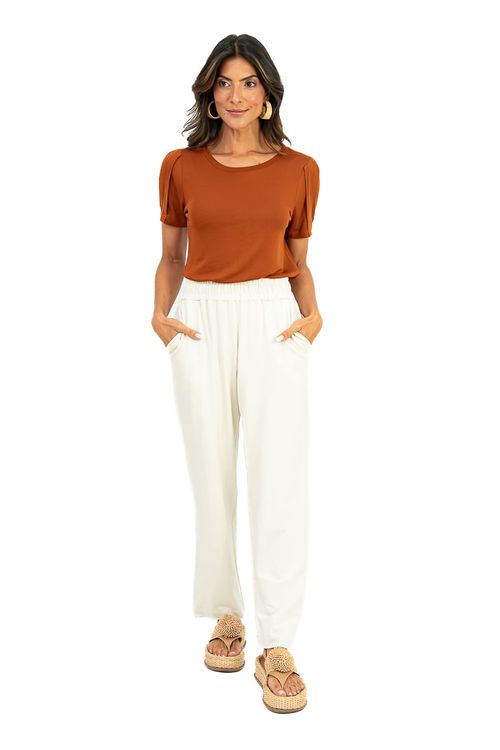 Modelo usando blusa chocolate com caimento leve combinada com calça off-white de cós elástico e sandália plataforma, look casual elegante