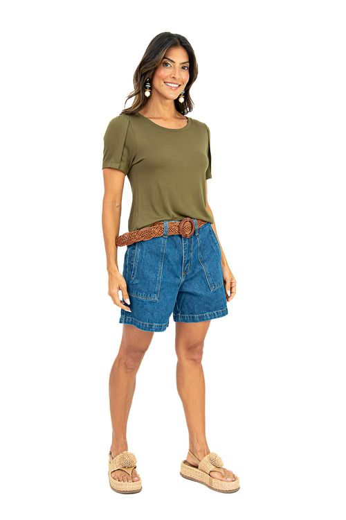 Blusa verde militar de caimento leve com falsa prega frontal, modelo com mãos nos bolsos, combinada com shorts jeans cintura alta e cinto trançado marrom