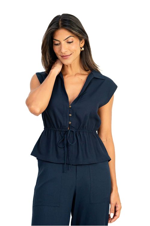 Blusa Amélia Cropped marinho vista frontal em modelo: gola clássica, abertura frontal com botões, túnel ajustável na cintura e barra peplum em tecido plano de linho.