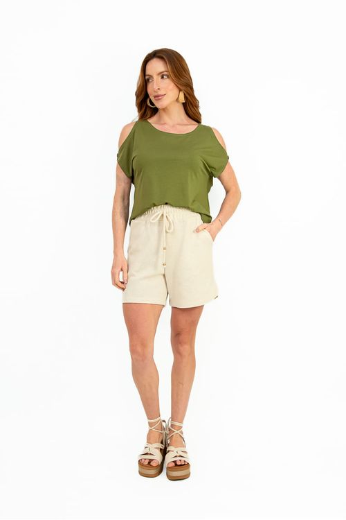 Detalhe do ombro vazado com botão na blusa verde, destacando o acabamento e a textura da leve malha.