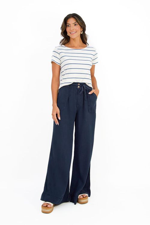Look completo em estúdio com blusa listrada UNO combinada a calça pantalona marinho de cintura alta, proposta office-casual, corpo inteiro sobre fundo branco.