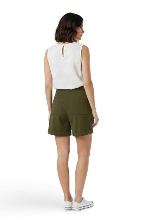 Shorts de alfaiataria verde visto de trás, mostrando os bolsos aplicados e a barra dobrada, detalhes do caimento e acabamento em modelo de pé.