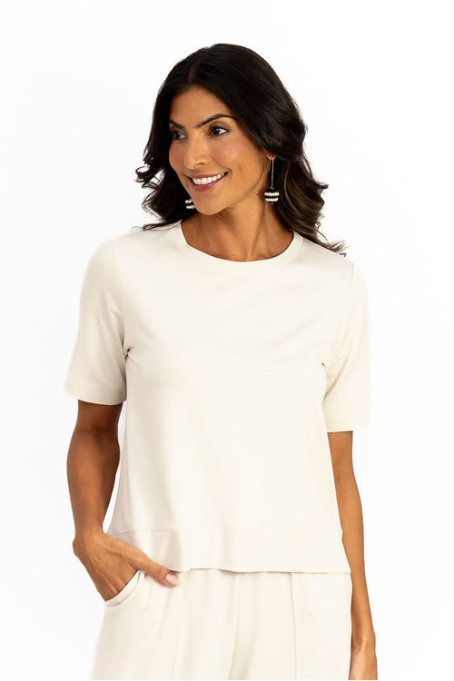 Close-up da blusa cropped Bossa em malha de viscose baunilha, gola redonda, meia manga e barra fraldada