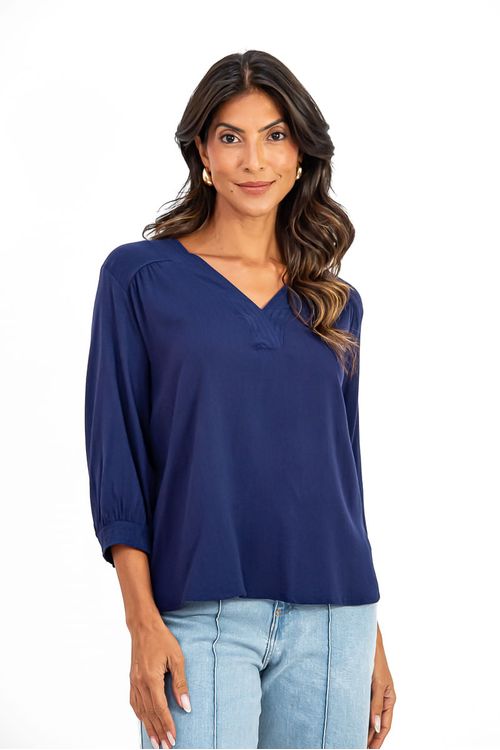 Vista lateral da blusa mostrando sua estrutura fluida e elegante; peça prática para uso diário em diversas ocasiões.