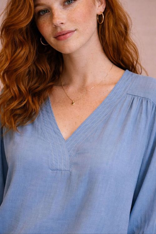 Conjunto completo com blusa azul claro de decote em V com pesponto, shorts de cintura média e lenço amarrado na cintura, estilo casual para o verão.