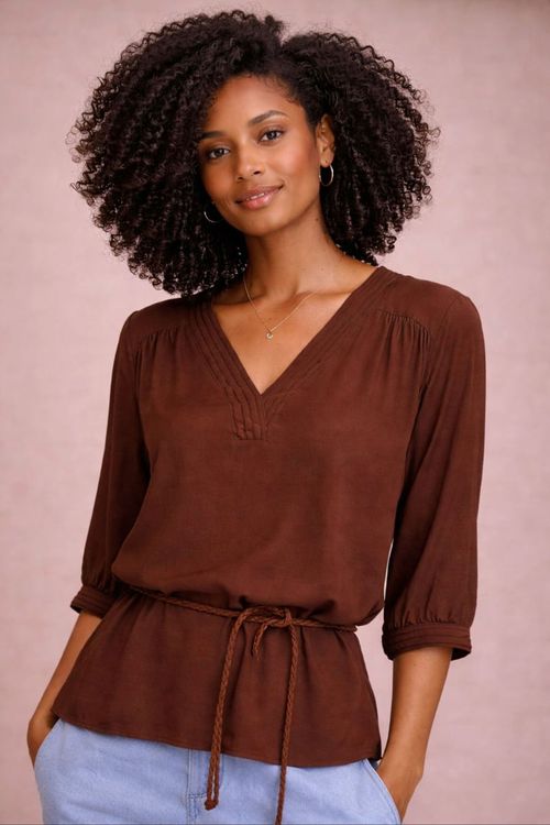 Look completo da bata café com cordão acinturando, combinada com shorts jeans claro e sandálias — estilo casual de verão.