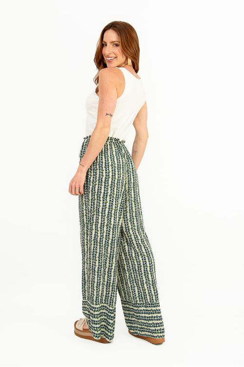 Conjunto completo com regata básica off white e calça pantalona estampada vertical em tons de verde, finalizado com sandália plataforma, estilo casual e fluido.