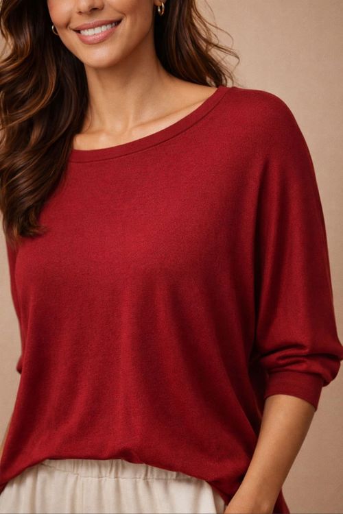 Close-up da blusa morcego vinho em malha de viscose, destaque do decote canoa, textura macia e manga 3/4 com punho.