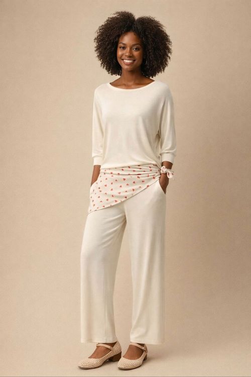 Look completo com blusa morcego baunilha e calça pantalona em malha de viscose, mostrando o caimento fluido da blusa e sapatilha neutra em styling casual sofisticado