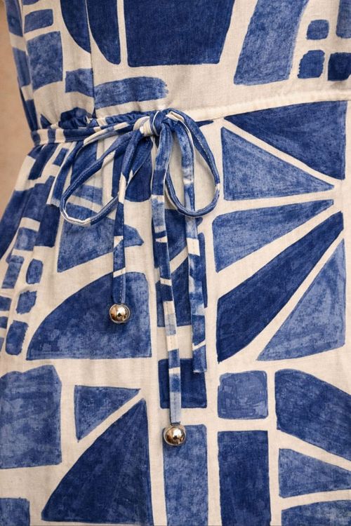 Close-up-do-tecido-com-estampa-ladrilho-geometrica-em-blocos-azuis-sobre-fundo-off-white-evidenciando-textura-viscose-slub-e-efeito-de-pinceladas