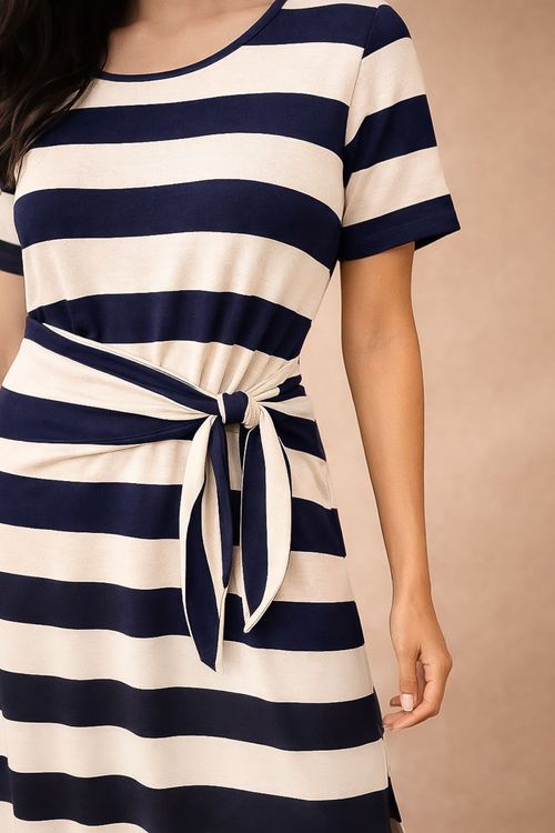 Close-up-do-vestido-listrado-marinho-mostrando-o-no-de-amarracao-lateral-padrao-de-listras-horizontais-largas-textura-moletinho-e-acabamento-do-decote-canoa