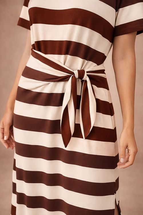 Close-up do vestido midi listrado café em malha viscose moletinho, detalhe da amarração lateral com drapeado e faixas horizontais largas em marrom e off white, mostrando textura suave e caimento.