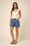 Modelo-vestindo-regata-em-off-white-com-decote-em-V-e-detalhe-de-recorte-frontal-combinada-com-shorts-jeans-e-mocassin-bege.