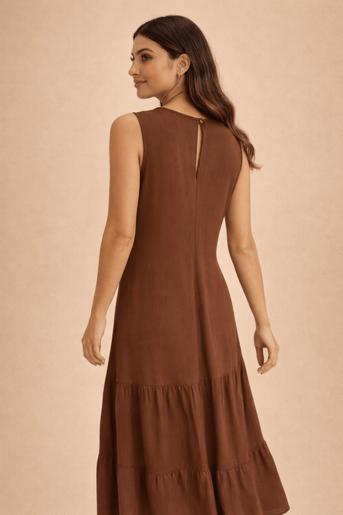 Vista-traseira-de-uma-mulher-vestindo-um-vestido-midi-marrom-com-botao-delicado-na-parte-de-tras-e-saia-com-duas-camadas.