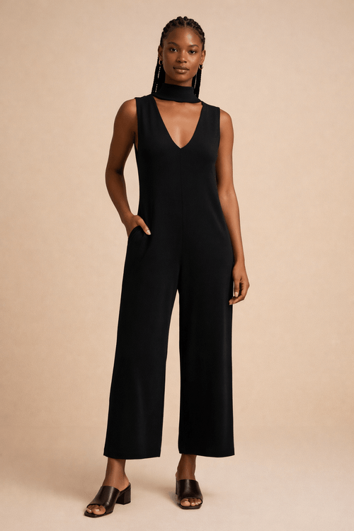 Macacão preto com decote em V e cintura ajustável, visto de frente.