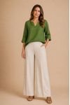 Blusa feminina verde com decote canoa e mangas 3/4, combinada com calça bege ampla, vista frontal.