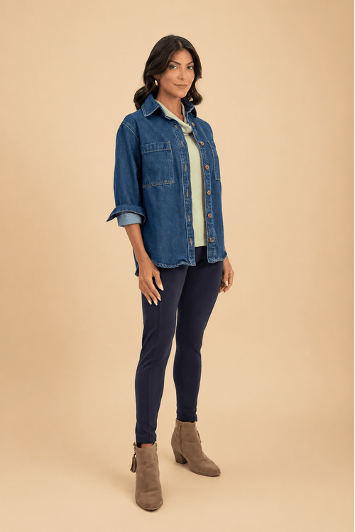Look completo com camisa jeans feminina azul escuro oversized, calça ajustada escura e bota de camurça em visual casual contemporâneo