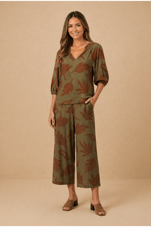 Modelo-vestindo-calca-pantacourt-estampada-com-blusa-terrosa-em-fundo-neutro.