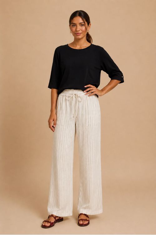 Modelo vestindo calça reta de linho risca de giz off white com blusa preta, vista frontal.